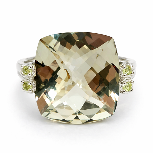 Ring with a large square-cut gemstone and smaller round stones on a white background