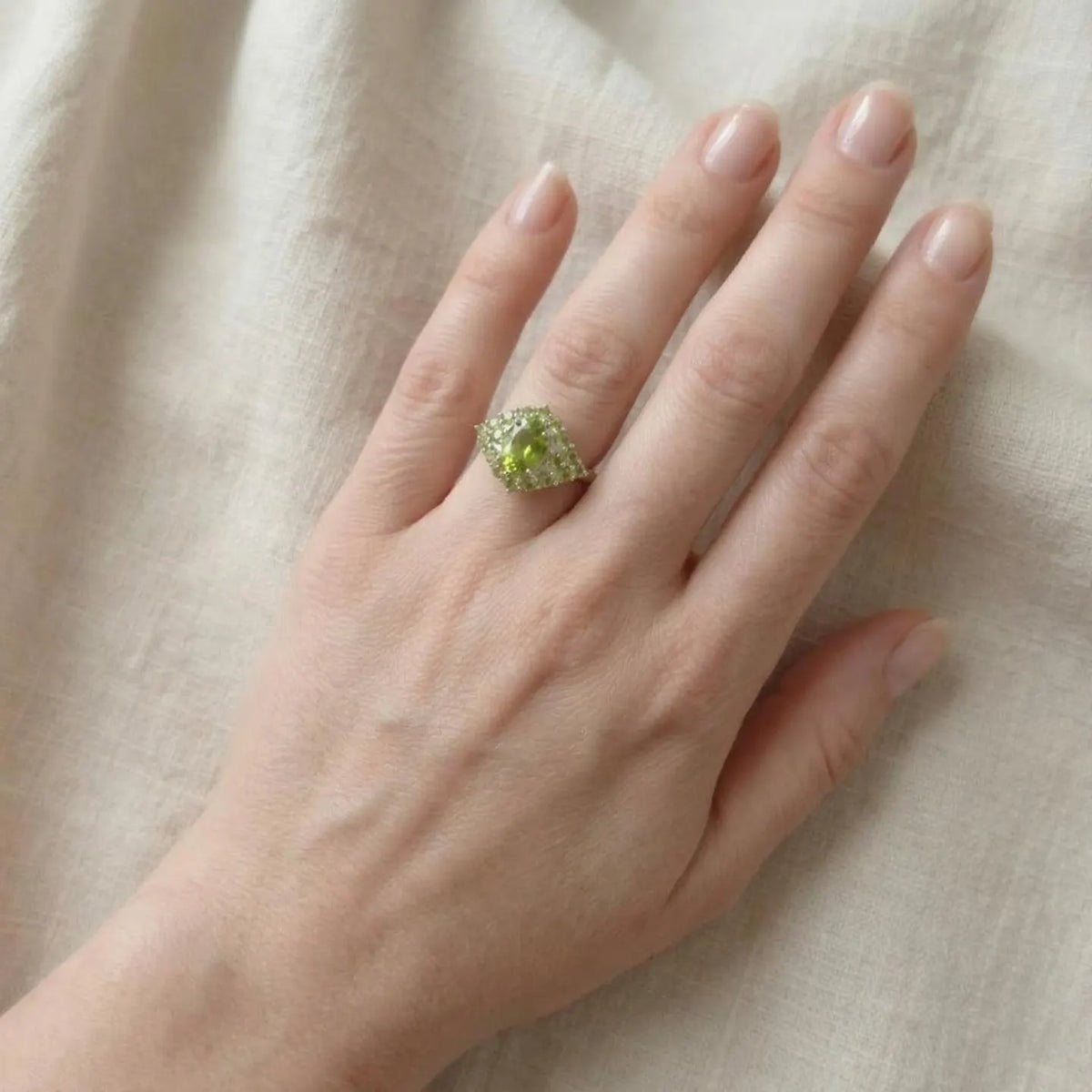 Peridot cluster sterling silver ring worn on a finger